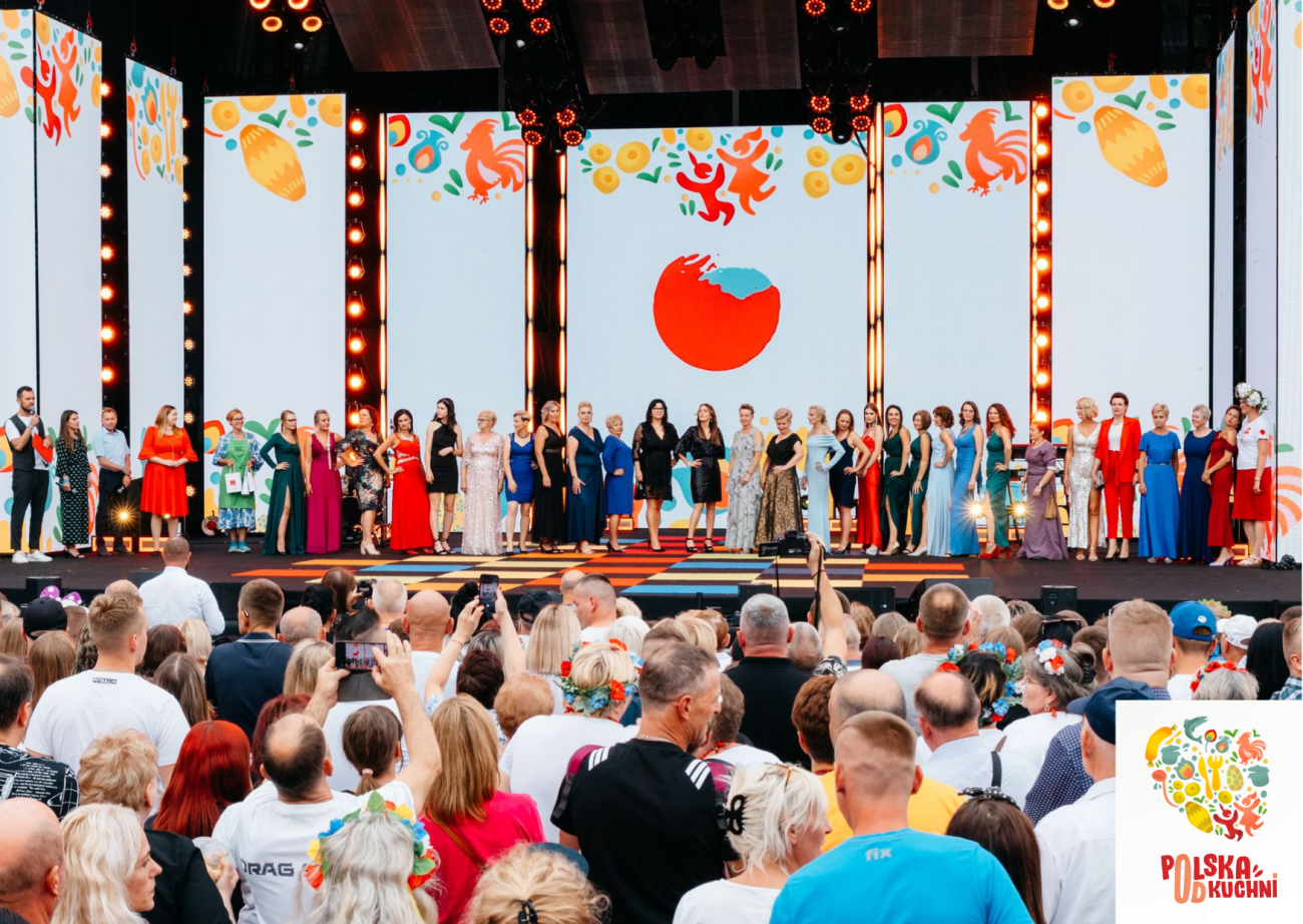 szeroki kadr, osoby stojące na scenie oraz widowia, kolorowe dekoracje