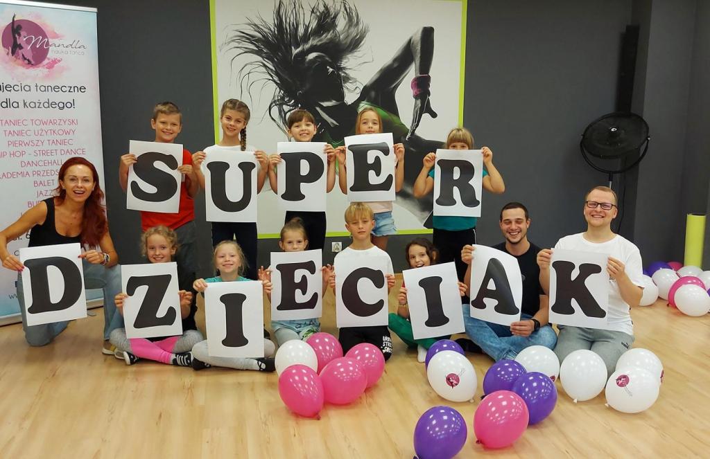 Uczestnicy trzymają napis "Super Dzieciak"