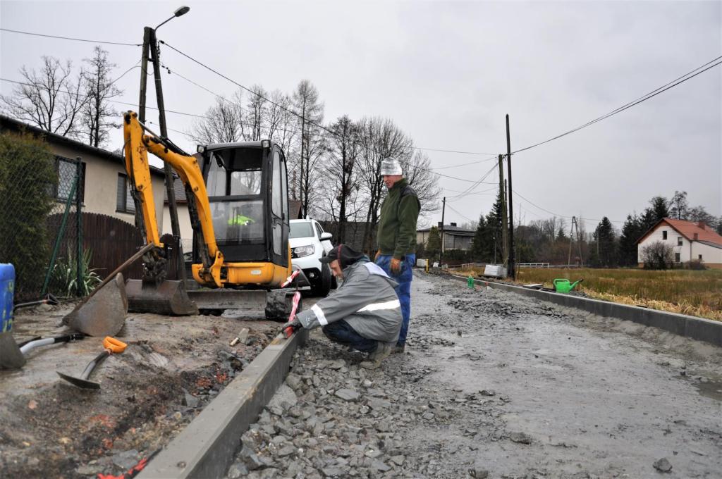 Układanie betonowych obrzeży trwa na ulicy Klonowej Układanie oporników na ulicy Klonowej. Na pierwszym planie robotnicy i koparka