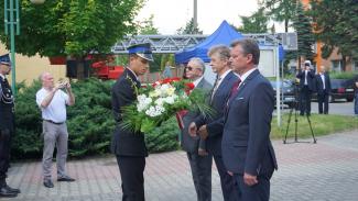 burmistrz i przewodniczący skadają kwiaty 
