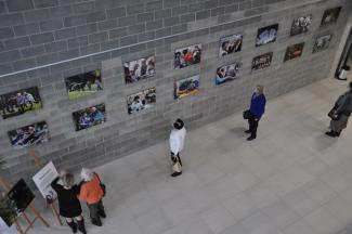 pensjonariusze oglądają wystawę - zdjęcia na ścianie 