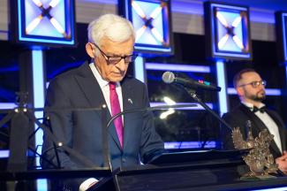Jerzy Buzek przy mówicy - przemawia
