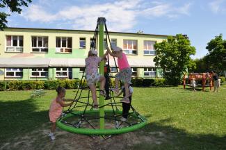 Dzieci bawiące się na stożku w otoczeniu zieleni
