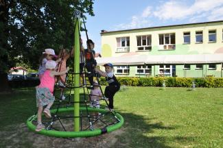 Dzieci bawiące się na stożku w otoczeniu zieleni