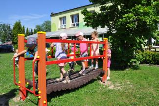 Dzieci bawiące się na mostku w otoczeniu zieleni