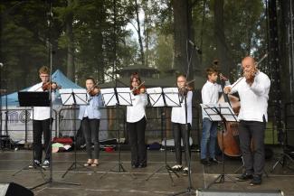 na scenie stoi 6 muzyków z kapeli kamila Krzanowskiego, grają na skrzypcach, jeden na kontrabasie