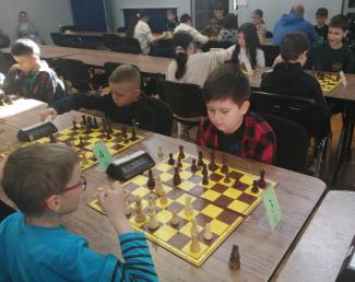 zawodnicy siędzący przy stołach, turniej szachowy