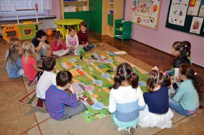 Przedszkolaki grające w grę na podłodze