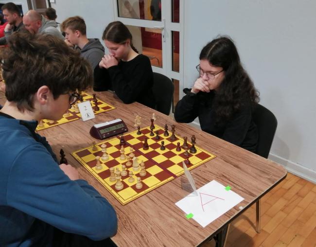 turniej ligi szachowej, ludzie siedzący przy stołach grają w szachy